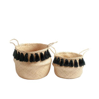 Two woven baskets with black tassels on a white background