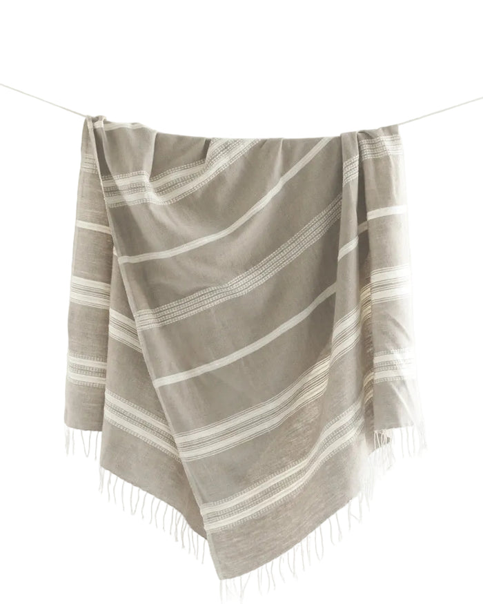 Taupe striped towel with fringe on a white background