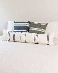 Set of striped pillows on a bed with a neutral background