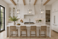 Modern kitchen with white island, bar stools, and pendant lights.