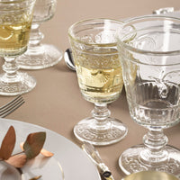 Decorative glassware with liquid on a beige tablecloth
