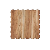 Square acacia wood cutting board with elegant scalloped edges, natural wood grain.