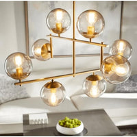Aiden Aged Brass Globe Chandelier with eight spherical glass lights and gilded linear frames.