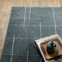 Alton Blue & Beige Casual Rug with a textured, power-loomed polyester weave and white grid pattern on wood floor.