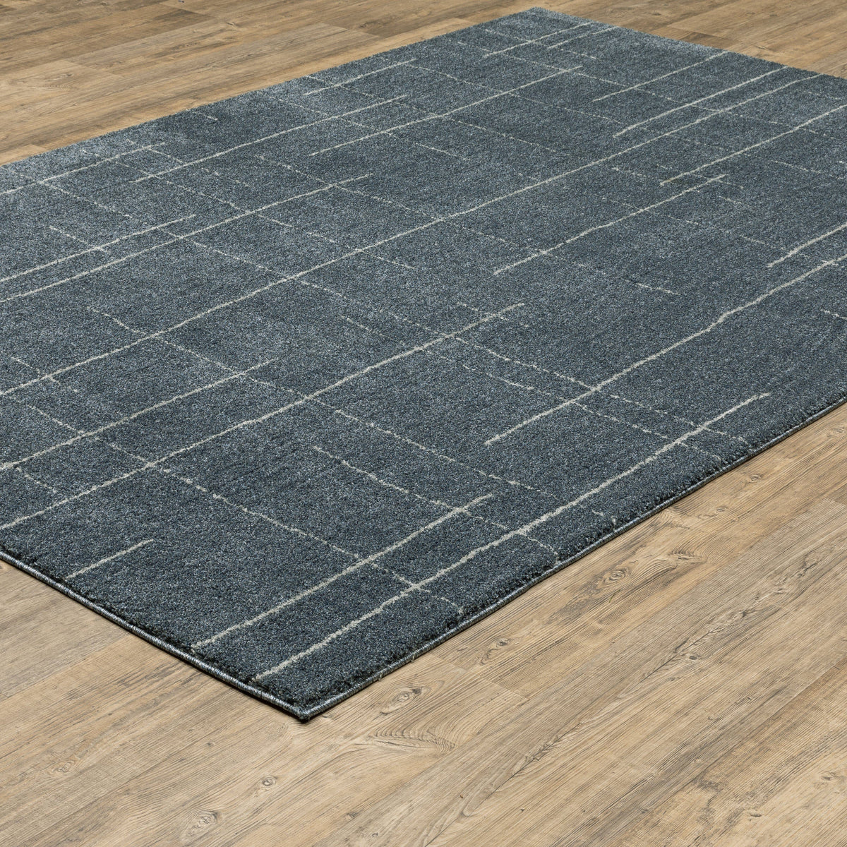 Alton Blue & Beige Casual Rug with abstract grid pattern on a wooden floor.