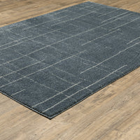 Alton Blue & Beige Casual Rug with abstract grid pattern on a wooden floor.