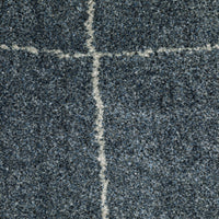 Alton Blue & Beige Casual Rug, close-up of dense, power-loomed polyester yarn with a white grid pattern.