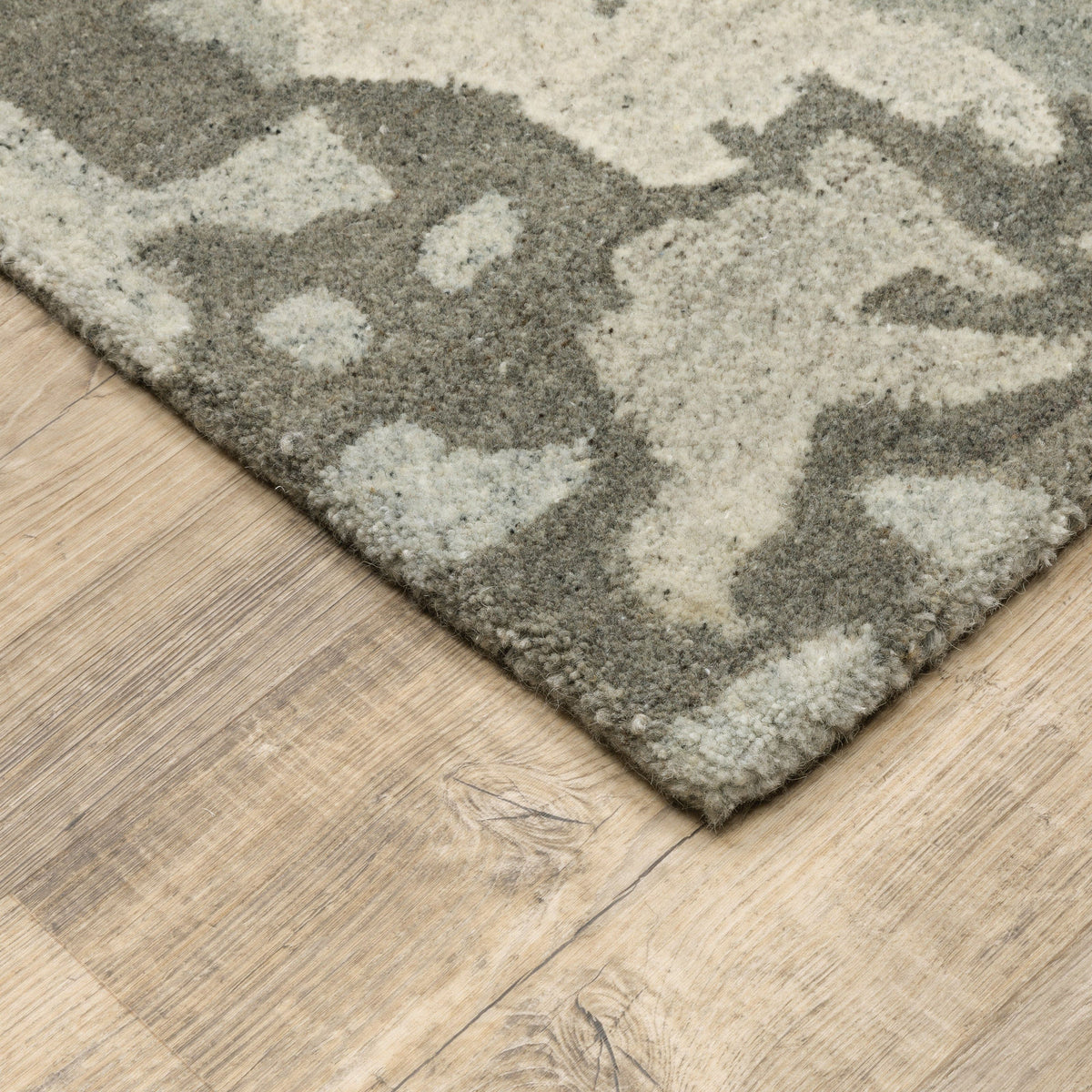 Handmade Anastasia Grey & Charcoal contemporary wool rug with modernized traditional patterns on a wood floor.