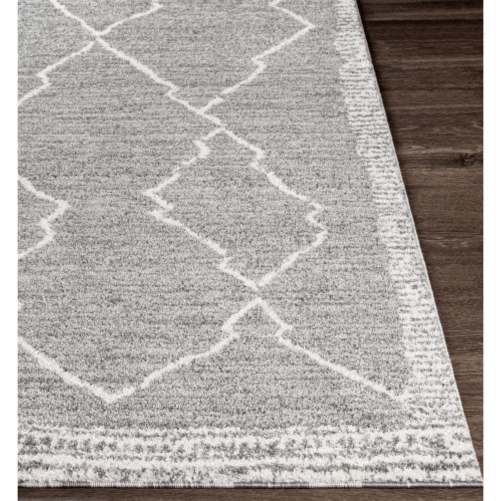 Andorra Charcoal & White polypropylene rug with a global geometric pattern on dark wood flooring.