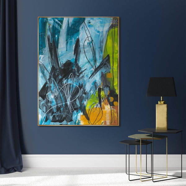 Abstract giclee canvas painting by Wendy Kleine, featuring blue, black, green, and orange brushstrokes in a gold frame, on a dark blue wall.