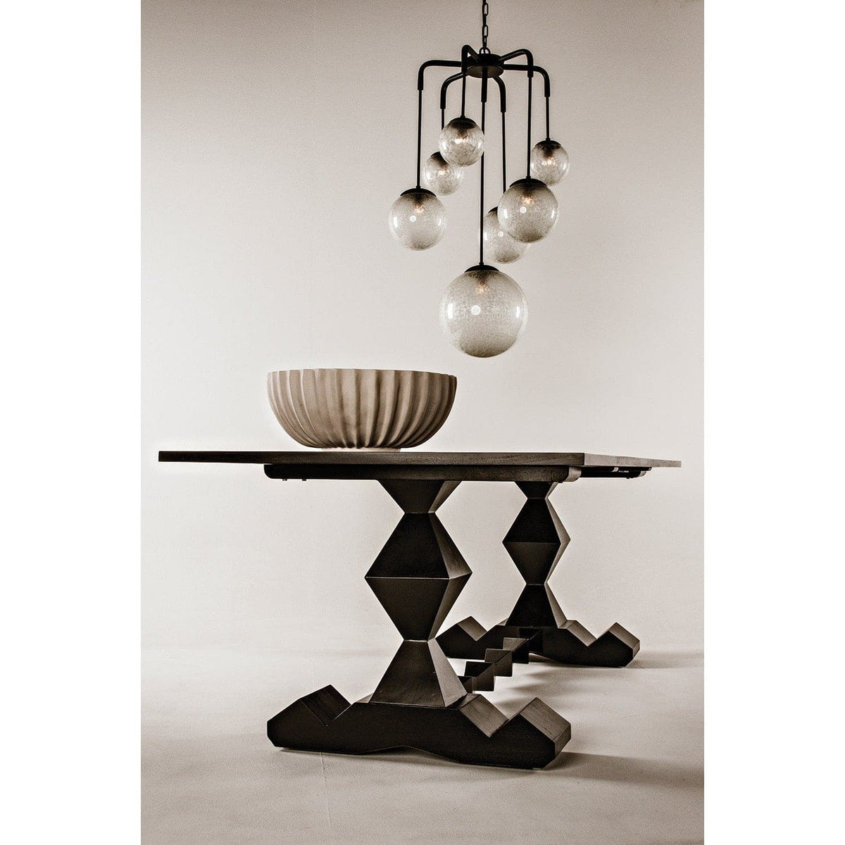Artemis Chandelier with seven handblown glass bubbles and black steel arms over a dark wood table.