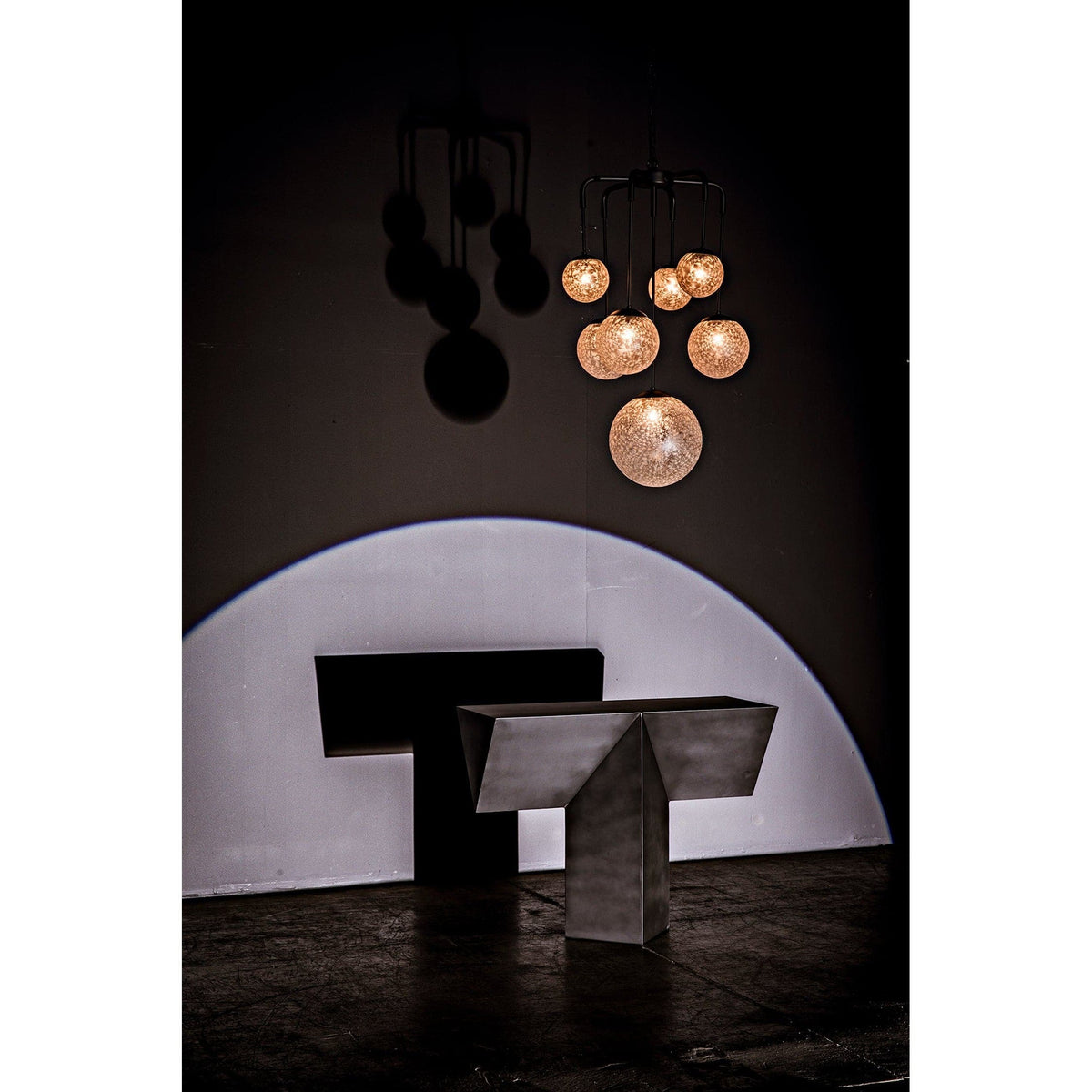 Artemis Chandelier with seven glowing handblown glass bubbles on black steel arms.