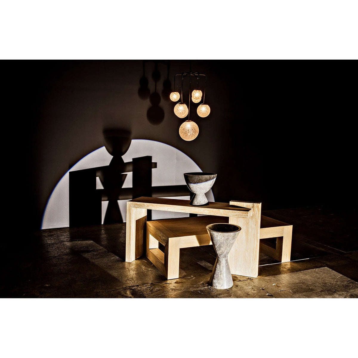 Artemis Chandelier with seven glowing glass bubbles and black steel arms, illuminating a modern wooden table.