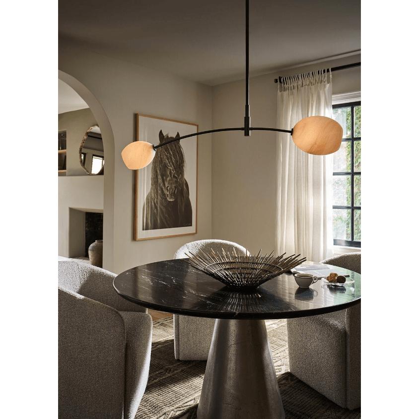 Artemis Double Pendant with alabaster-like glass globes on a polished nickel arched arm over a dining table.