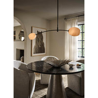 Artemis Double Pendant with alabaster-like glass globes on a polished nickel arched arm over a dining table.