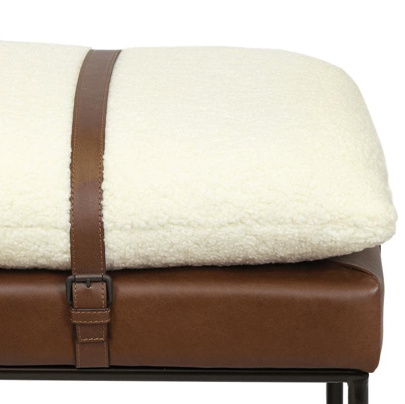 Aspen bench with a white boucle wool cushion strapped to a brown leather base.