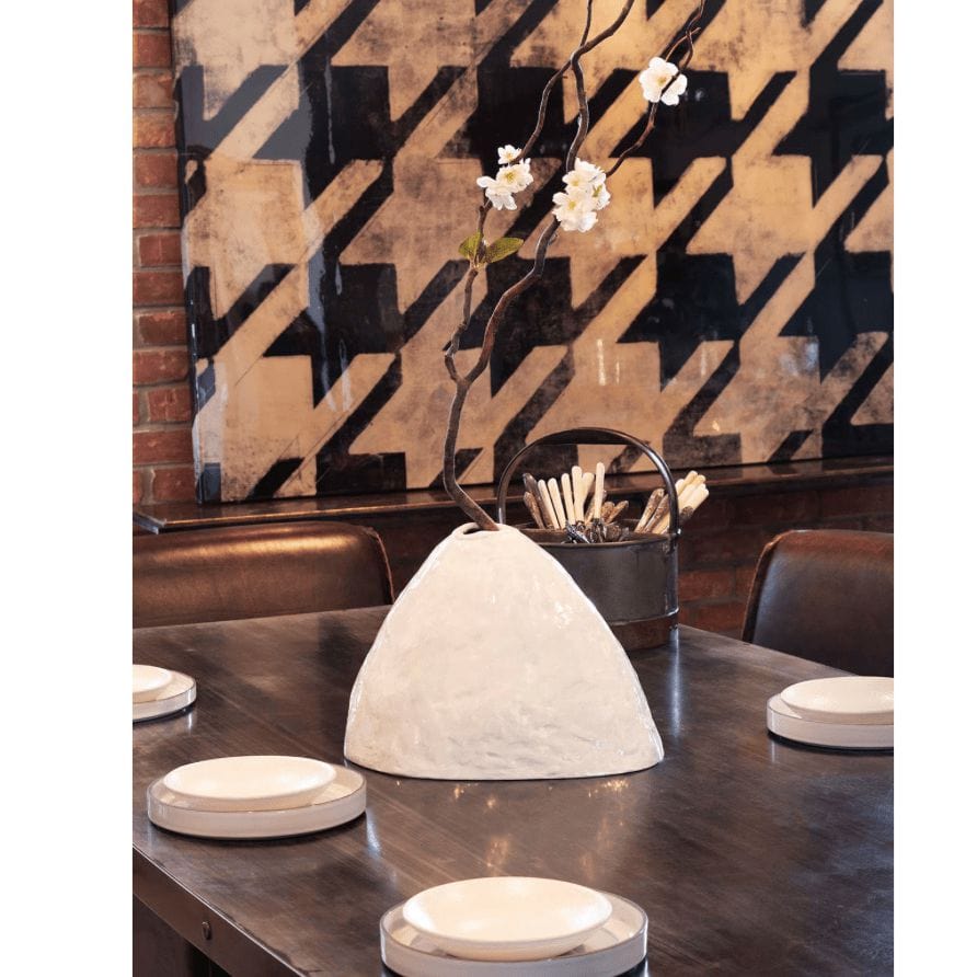 Glossy white Atlas ceramic vase with organic, hand-molded design, holding a branch with white flowers.