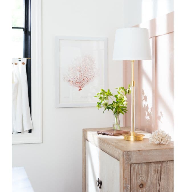Auburn Gold Leaf Crystal Buffet Lamp with a tall, slender gold body and crisp natural linen shade on a wooden cabinet.
