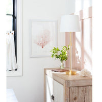 Auburn Gold Leaf Crystal Buffet Lamp with a tall, slender gold body and crisp natural linen shade on a wooden cabinet.