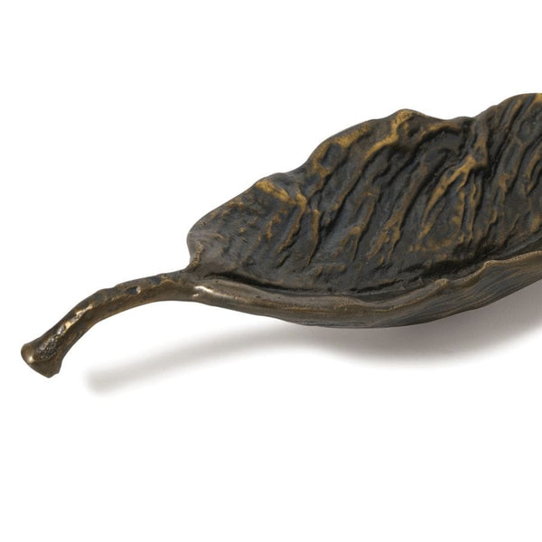 Dark bronze cast iron bowl shaped like a fallen leaf with raised organic texture.