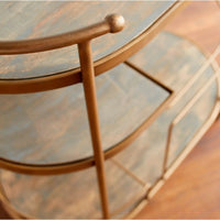 Antique Brass bar cart with Art Deco design, two glass shelves, and durable stainless steel frame.
