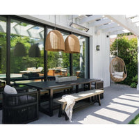 Two large weathered natural rattan-like Beehive outdoor pendant lights hang over a patio dining table.