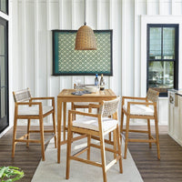 Beehive outdoor pendant with a natural rattan-like woven domed shade hanging over a wooden patio dining set.