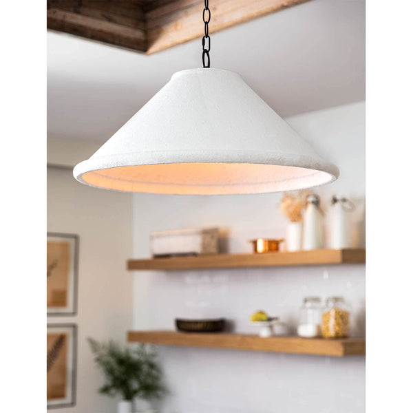 Large Billie concrete pendant light with a flared, rough-hewn white shade and black chain, illuminating a kitchen.