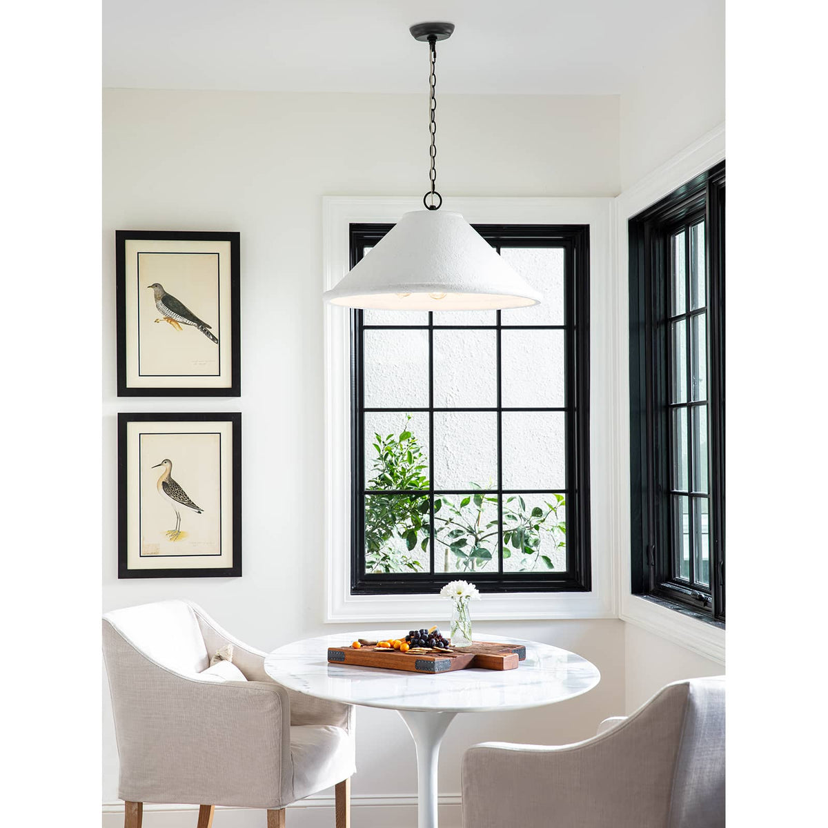 Large Billie concrete pendant light with a rough-hewn texture and flared silhouette, hanging in a bright room.