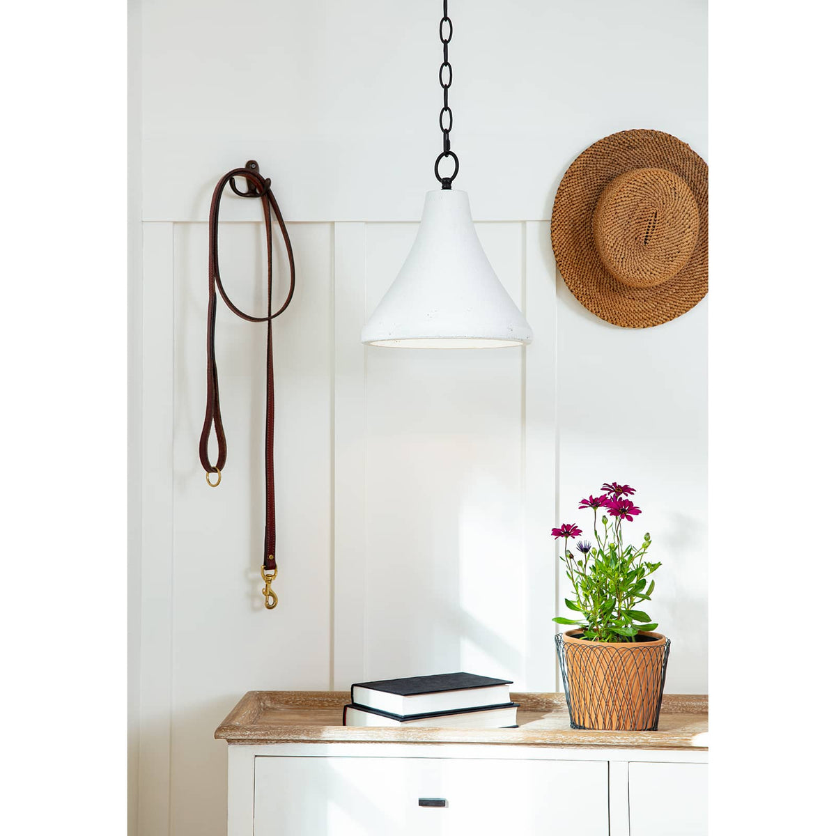 Small Billie concrete pendant light with a bell-shaped silhouette and rough-hewn texture, hanging from a black chain.