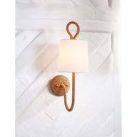 Nautical Bimini Sconce with natural woven seagrass, looped detailing, and a white linen shade on a white wall.