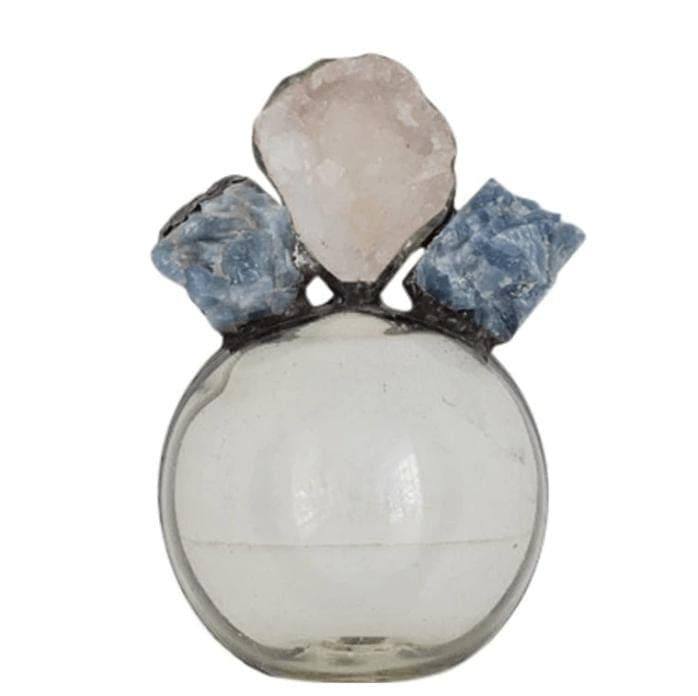 Round clear glass bottle with a light pink geode and two blue calcite pieces on top.
