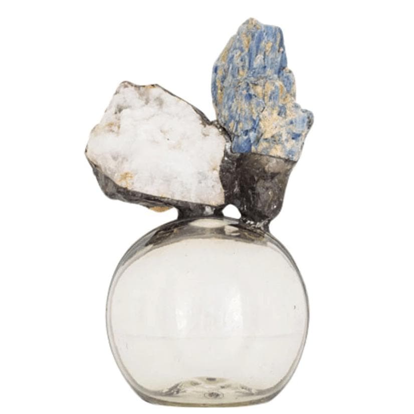 Round glass bottle with blue kyanite and white geode mineral display.