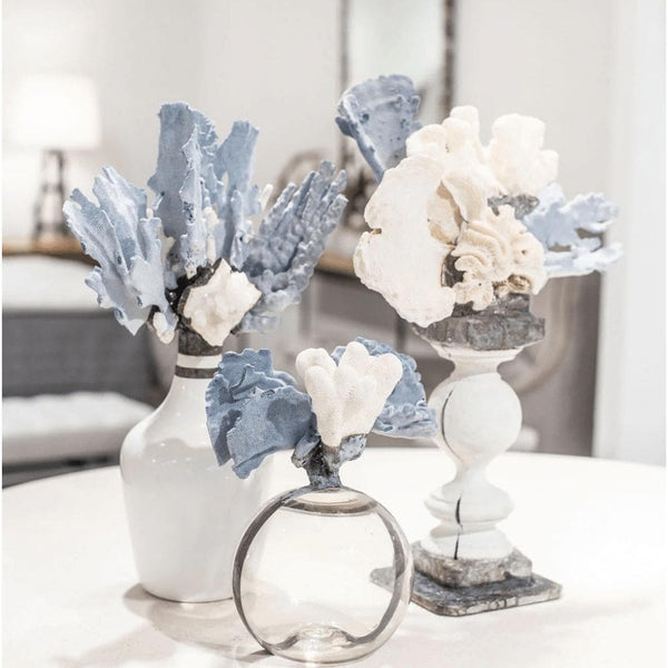 Blue and white coral decorative bottle, round glass float, and two larger coral arrangements.