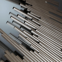Close-up of a Borealis Graphite Mirror, showing thin iron strips forming a geometric ring design.