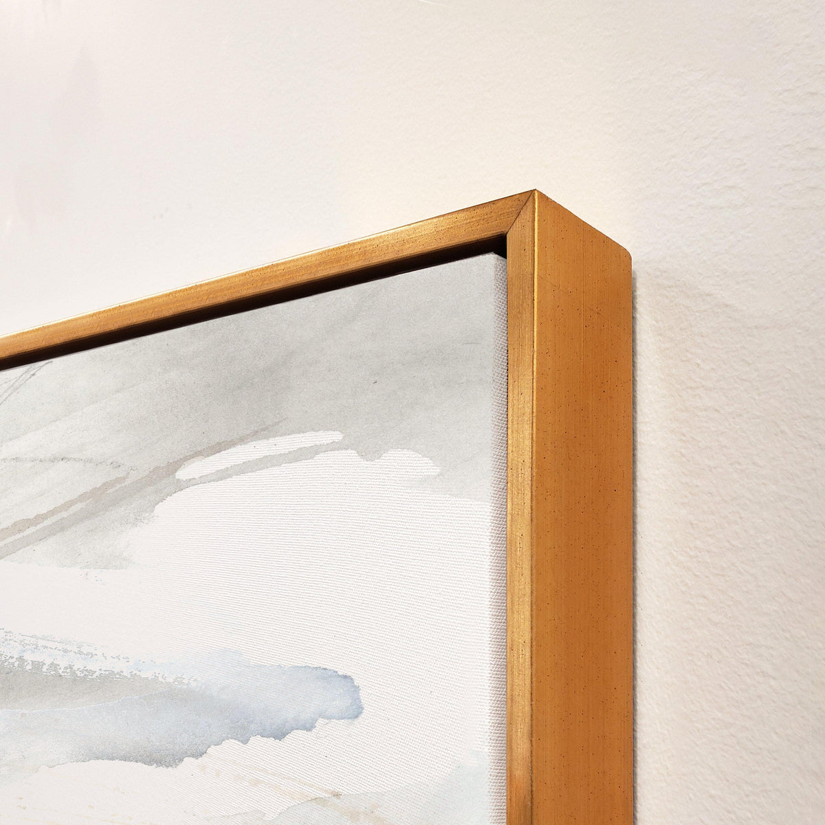 Abstract giclee canvas art with soft gray and blue brushstrokes, framed in a gold floating frame.