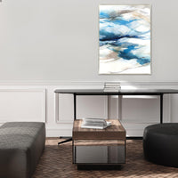 Abstract giclee canvas painting with blue, white, and brown brushstrokes, framed, hanging above a console table.