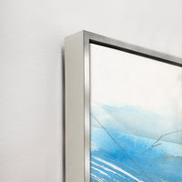 Abstract giclee canvas painting with blue and white brushstrokes, featuring a sleek silver frame.