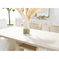 Reclaimed wood Bridge Dining Table with white wash finish, angular pedestal base, and pampas grass decor.