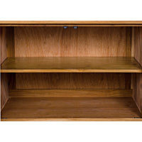 Interior of a Brook Teak & Sea Grass sideboard, showing two empty wooden shelves.