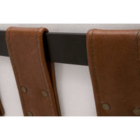 Close-up of Chestnut Top Grain Leather straps with brass rivets on a black frame and pearl fabric.