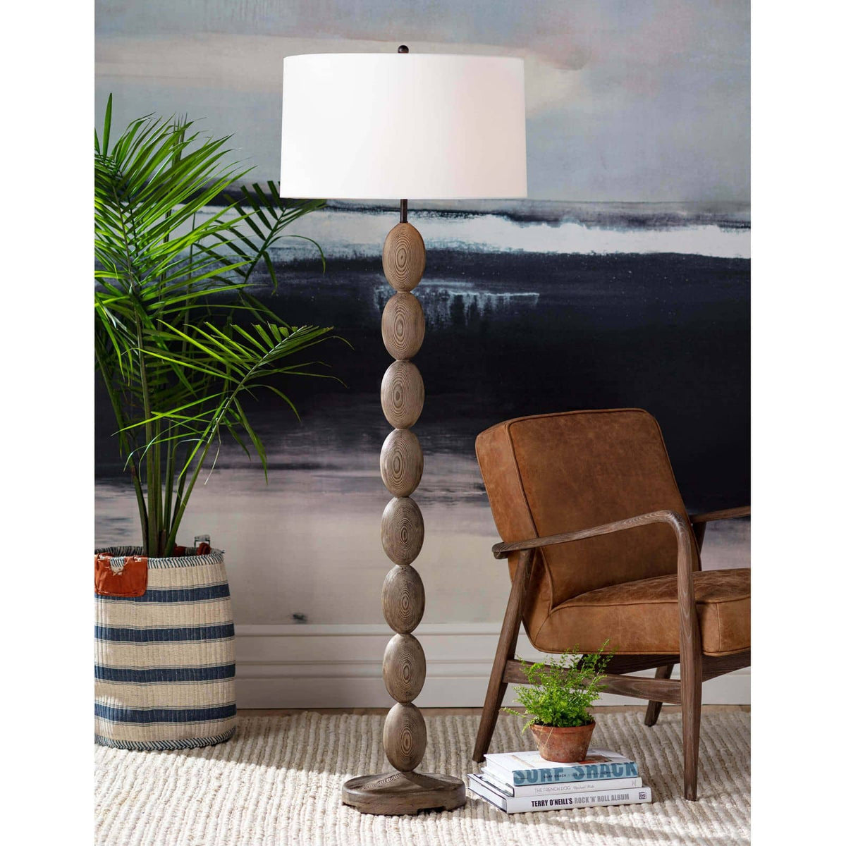 Buoy floor lamp with stacked birch wood base, natural linen drum shade, and polished brass hardware.