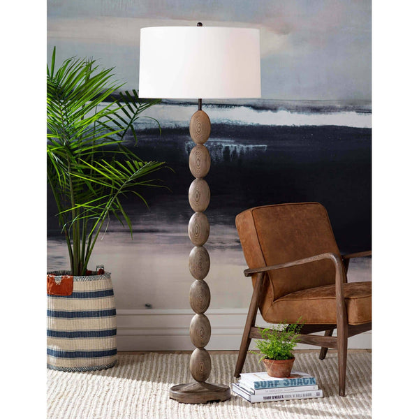 Buoy floor lamp with stacked birch wood base, natural linen drum shade, and polished brass hardware.