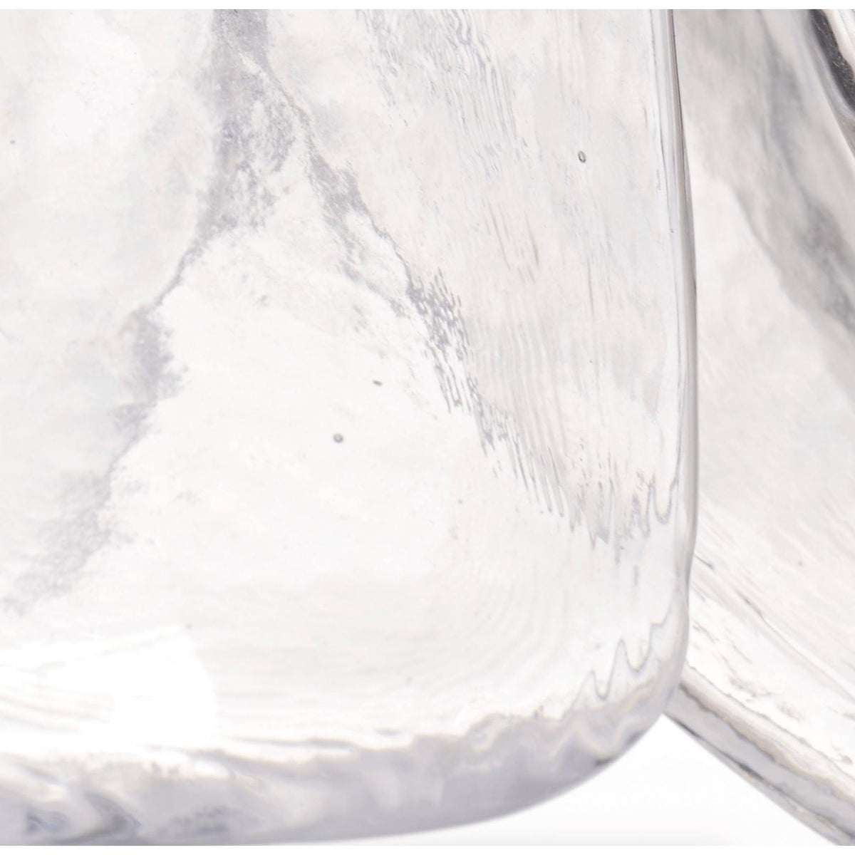 Close-up of a clear, hand-blown glass pendant light shade with subtle ripples and an organic, calla lily-inspired shape.