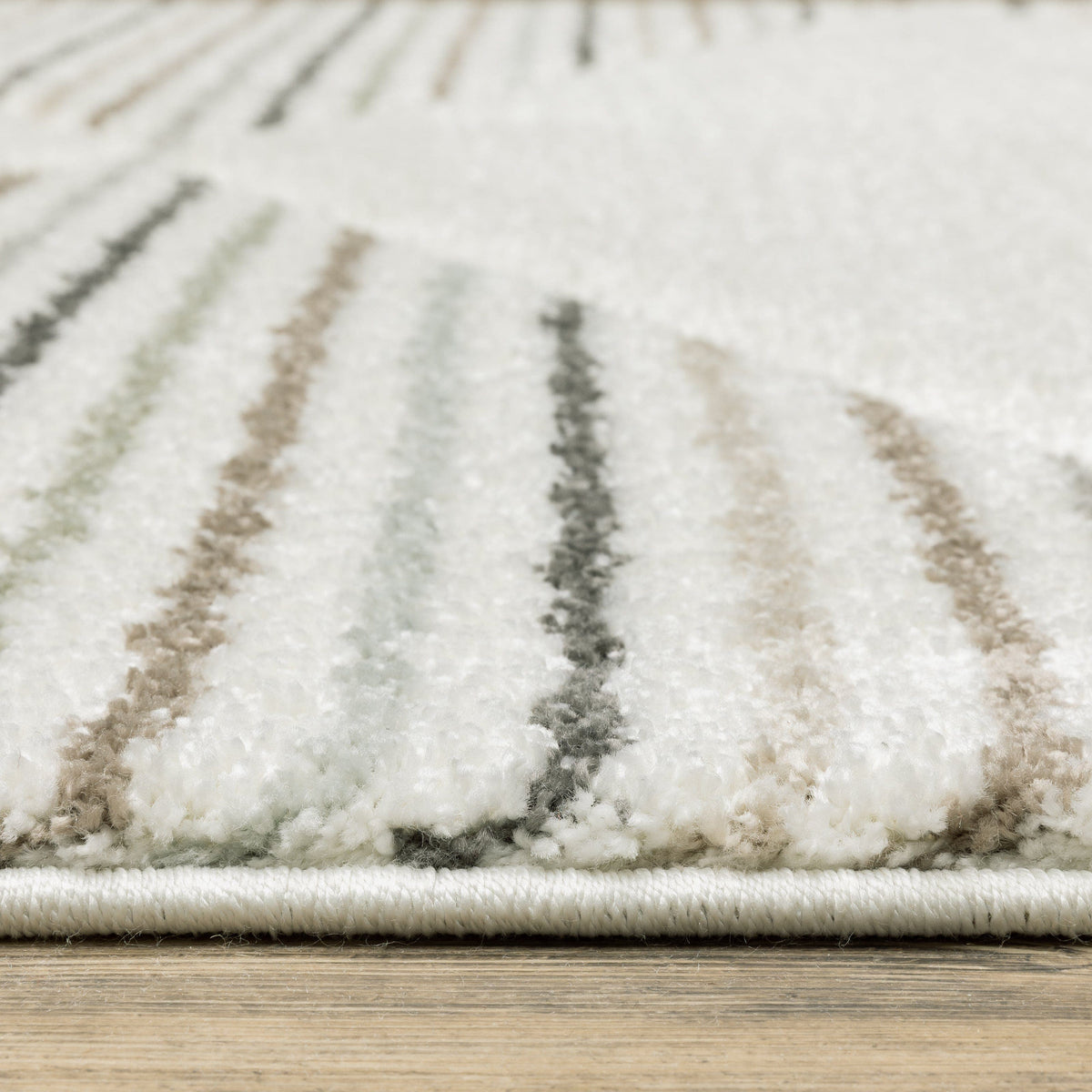 Close-up of a Cambria Beige & Multi Casual Rug, showing its soft polypropylene pile with carved texture and subtle striped design in neutral, pale blue, and mint hues.