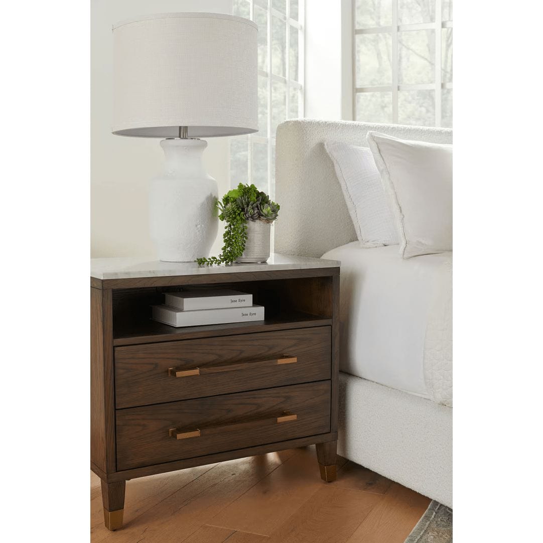 Cambria brown oak and marble nightstand with two drawers, an open cubby, and gold-capped legs.