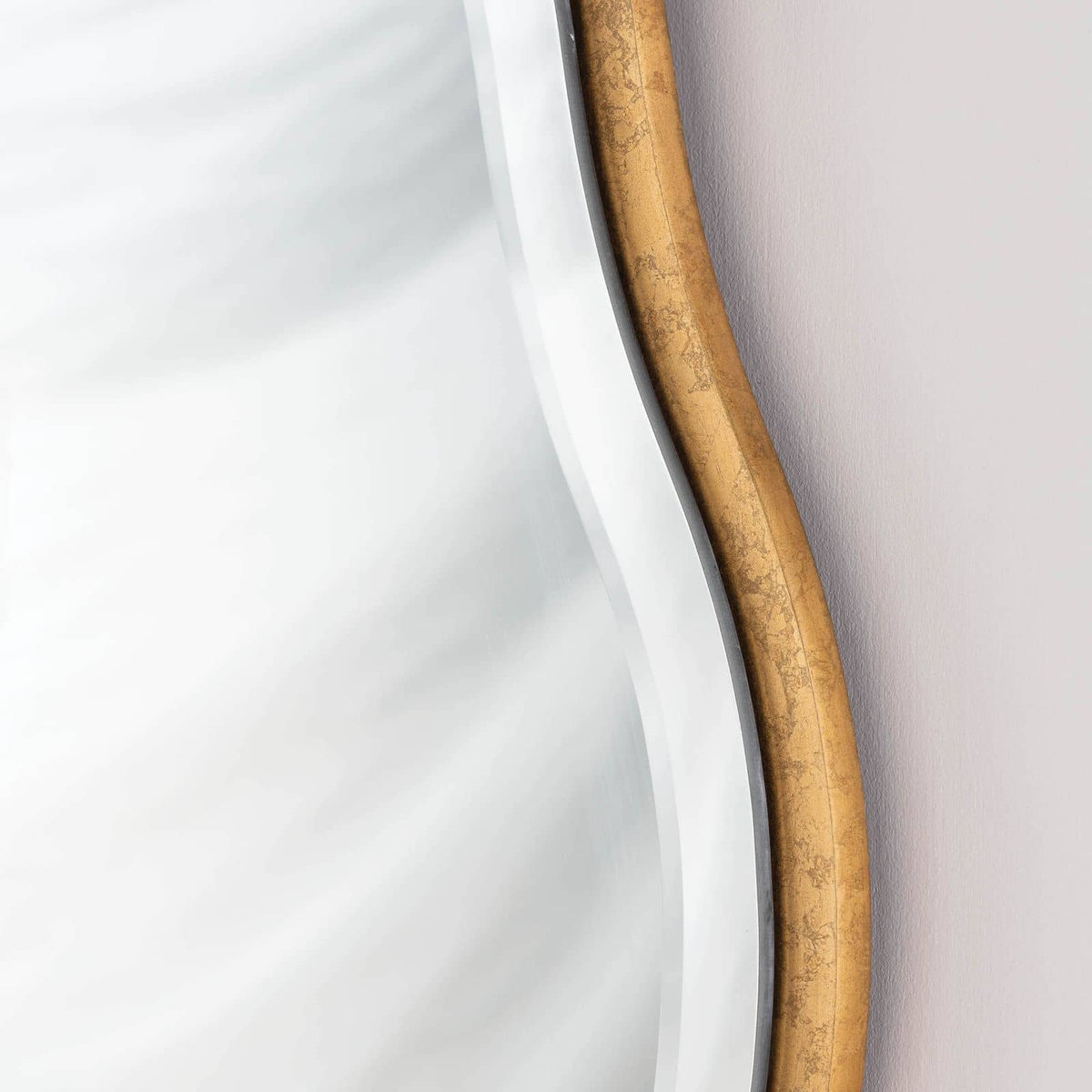 Candice Gold Leaf Mirror with a soft, undulating frame and beveled edge.
