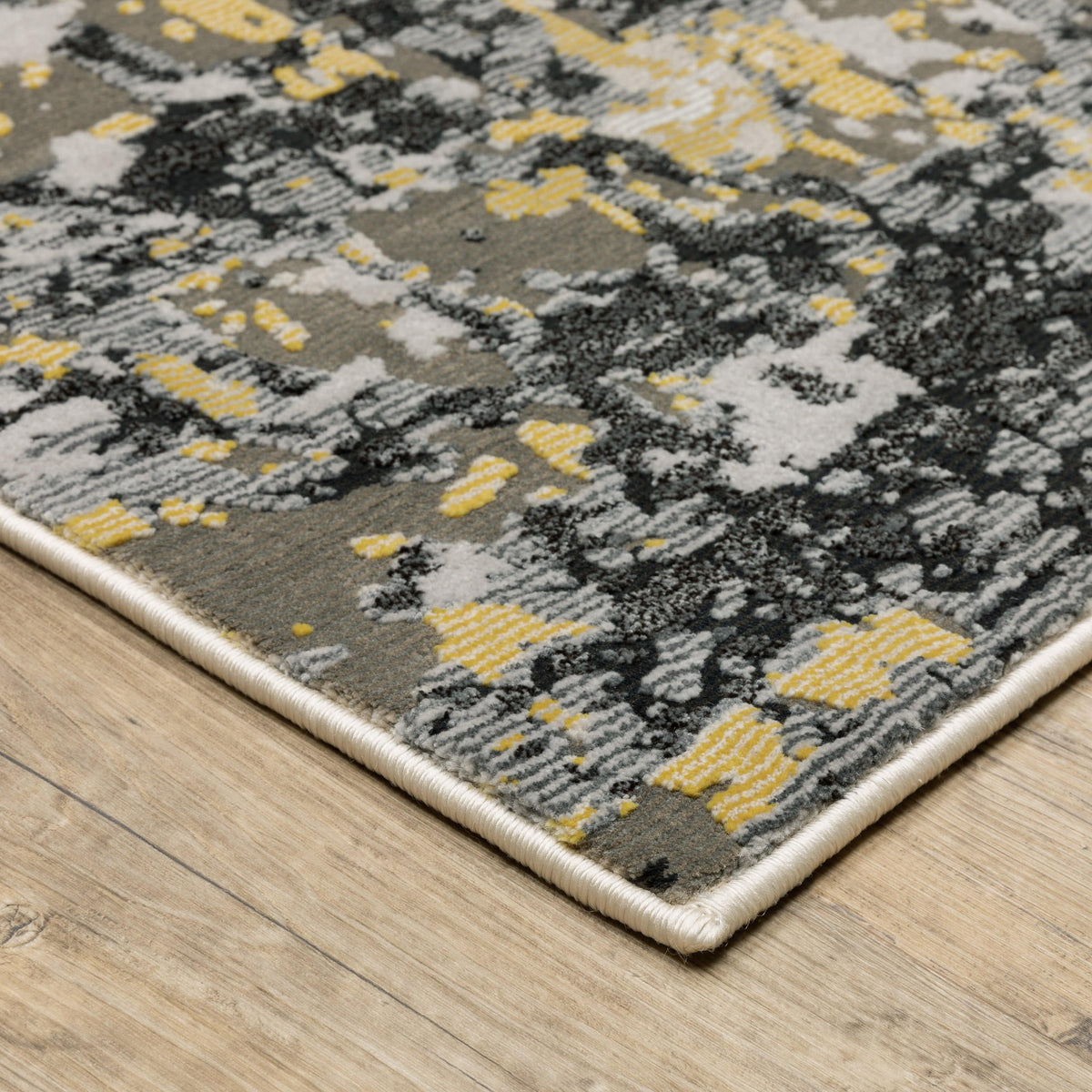Caravan Beige & Gold Contemporary Rug with abstract gray, black, and yellow pattern on a wooden floor.