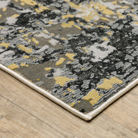 Caravan Beige & Gold Contemporary Rug with abstract gray, black, and yellow pattern on a wooden floor.