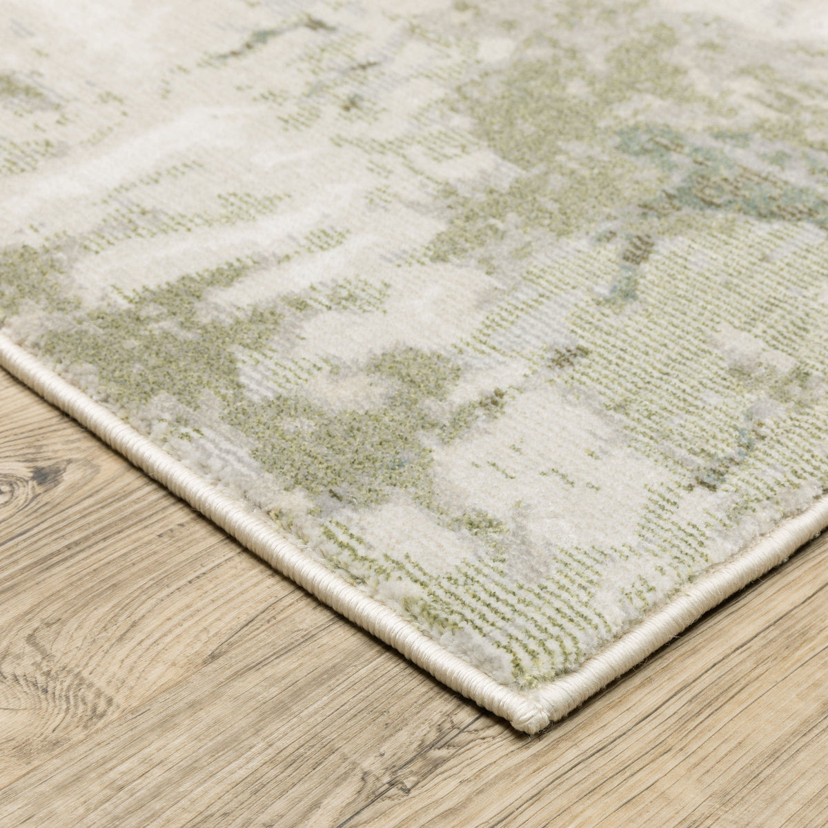 Caravan Beige & Green Contemporary Rug with textured polyester yarns on a wooden floor.